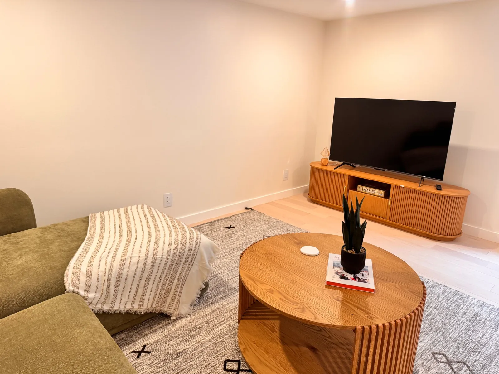 Lower-level TV lounge with a fluted oak media console