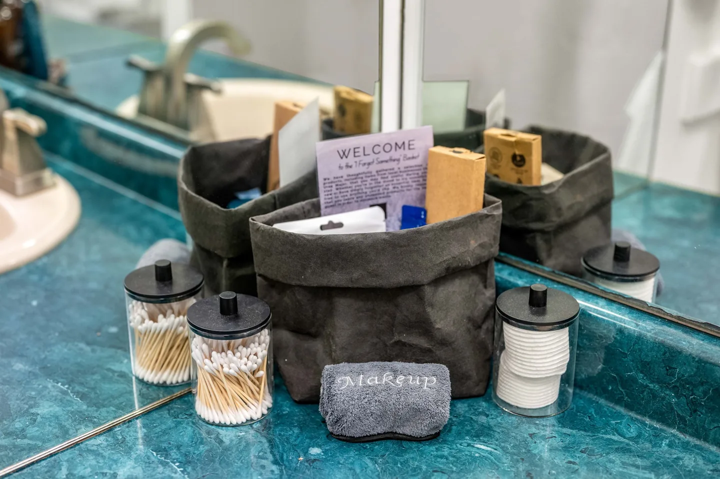 “I Forgot Something” basket with cotton swabs, cotton rounds and a makeup cloth on the primary bathroom counter