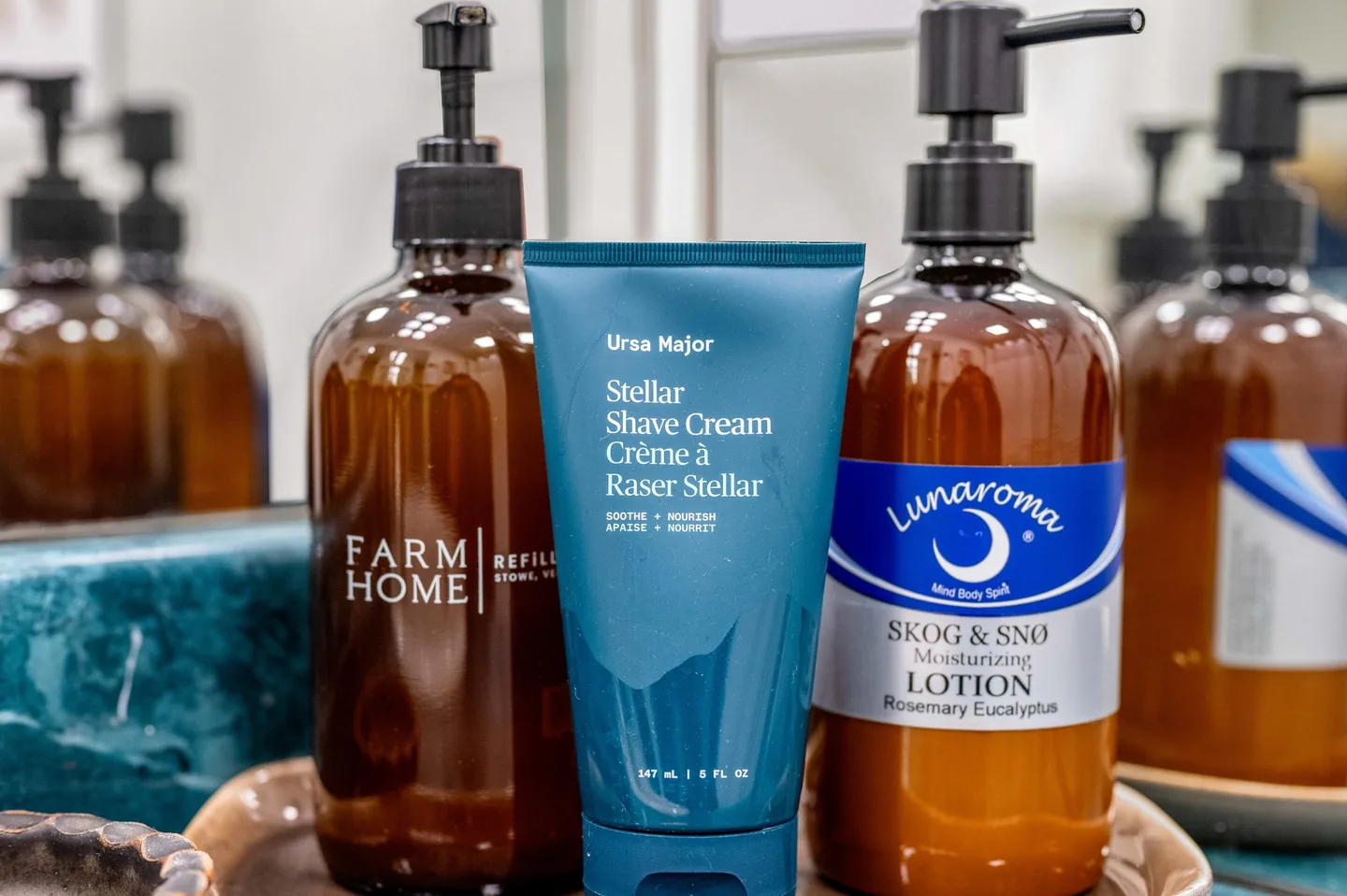 Lunaroma Skog & Snø rosemary eucalyptus lotion, Ursa Major shave cream and Farm Home hand soap on a tray in the primary bathroom
