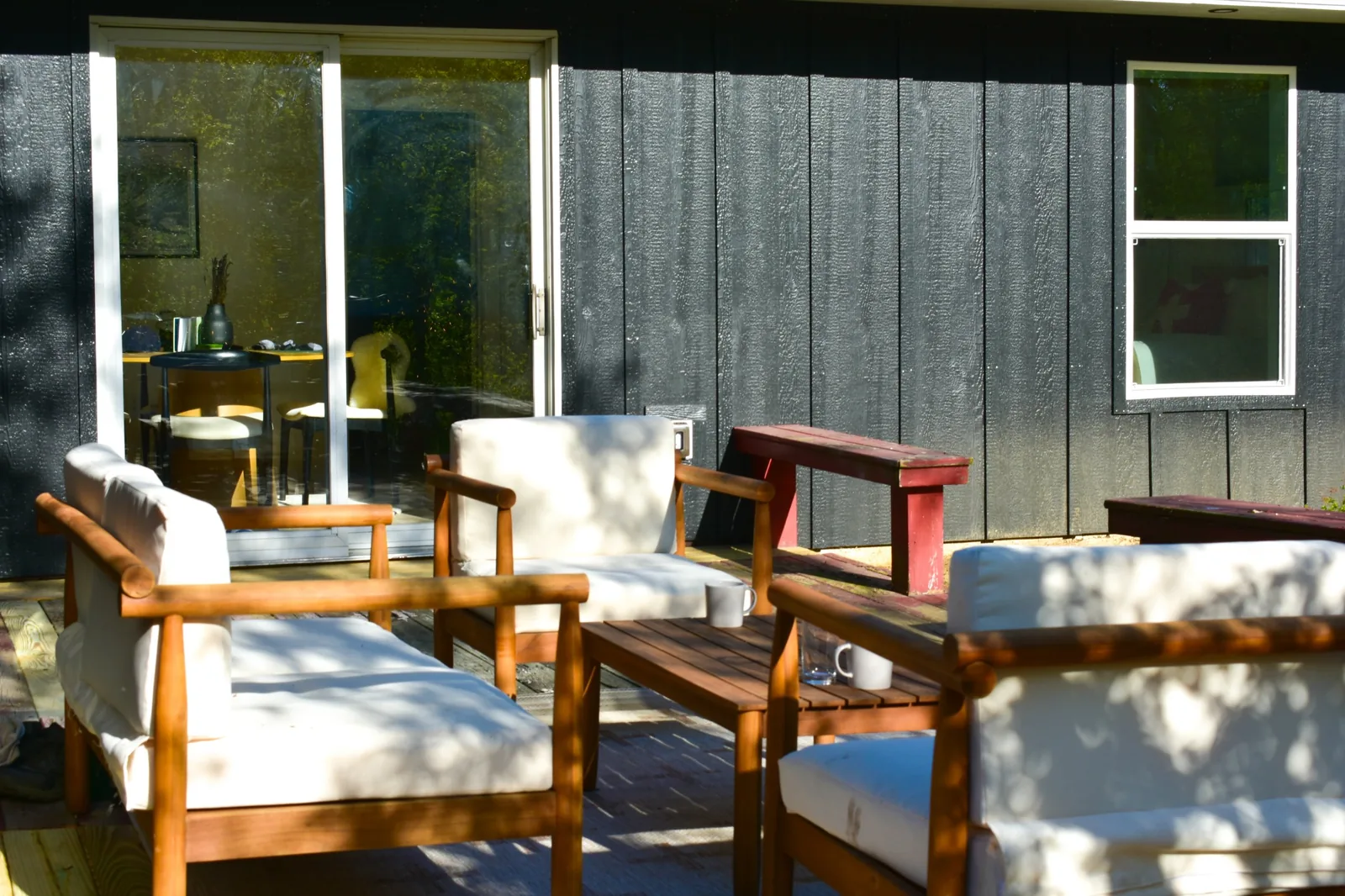 Deck lounge seating beside the sliding glass doors with a propane Weber grill nearby