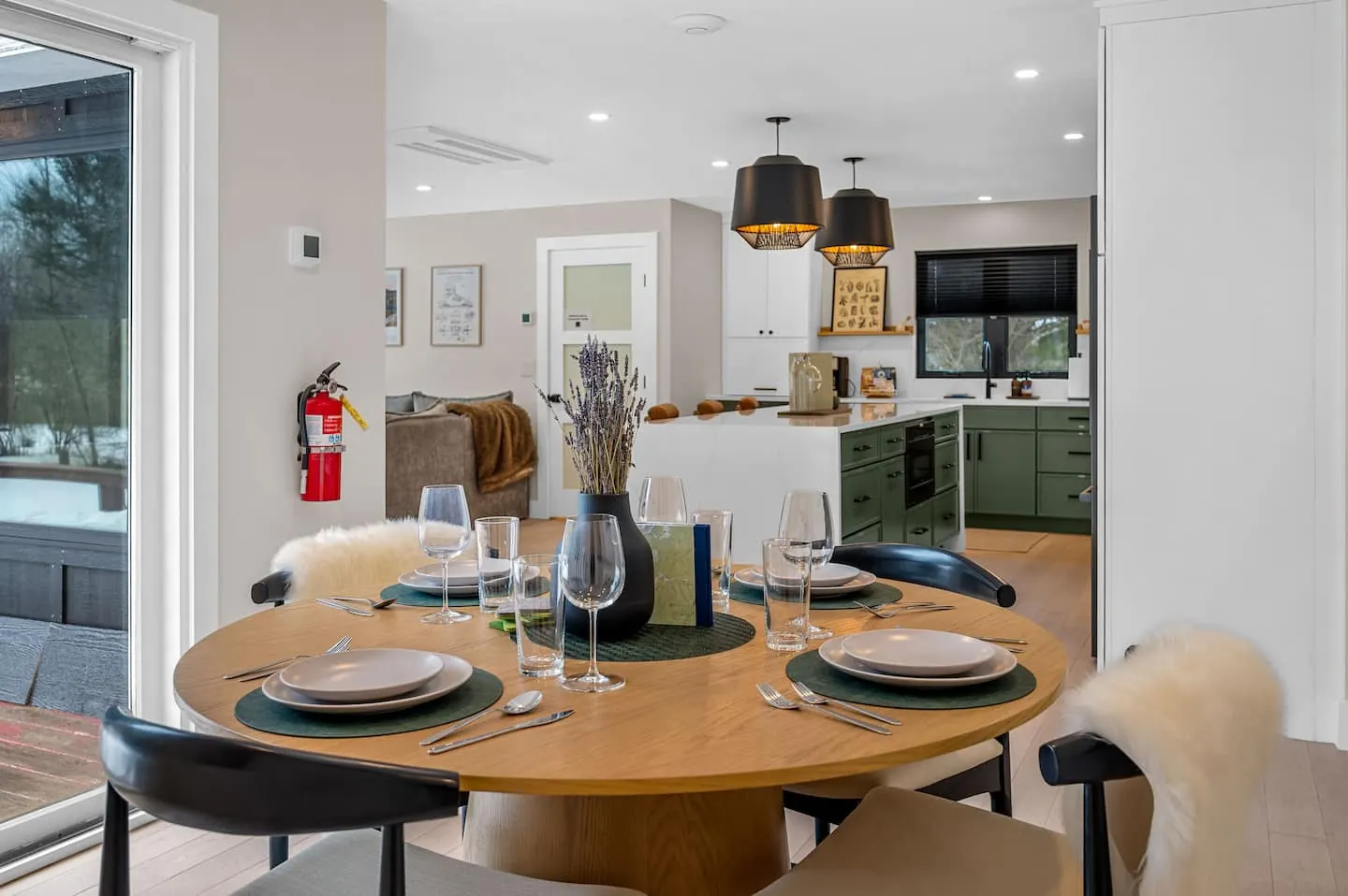 Round wooden dining table set for dinner beside the kitchen