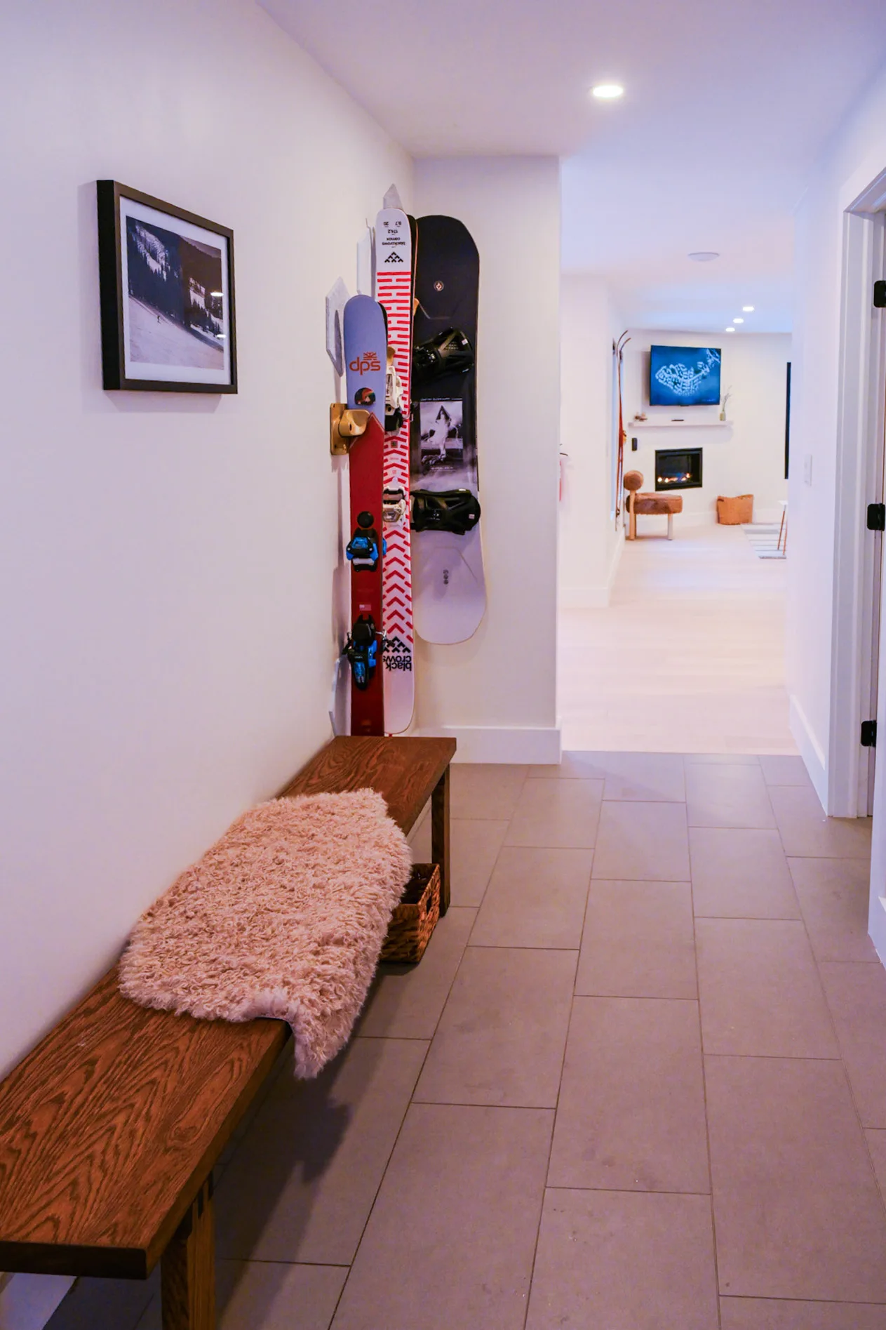 Entry hall with a wood bench and wall racks for skis and snowboards