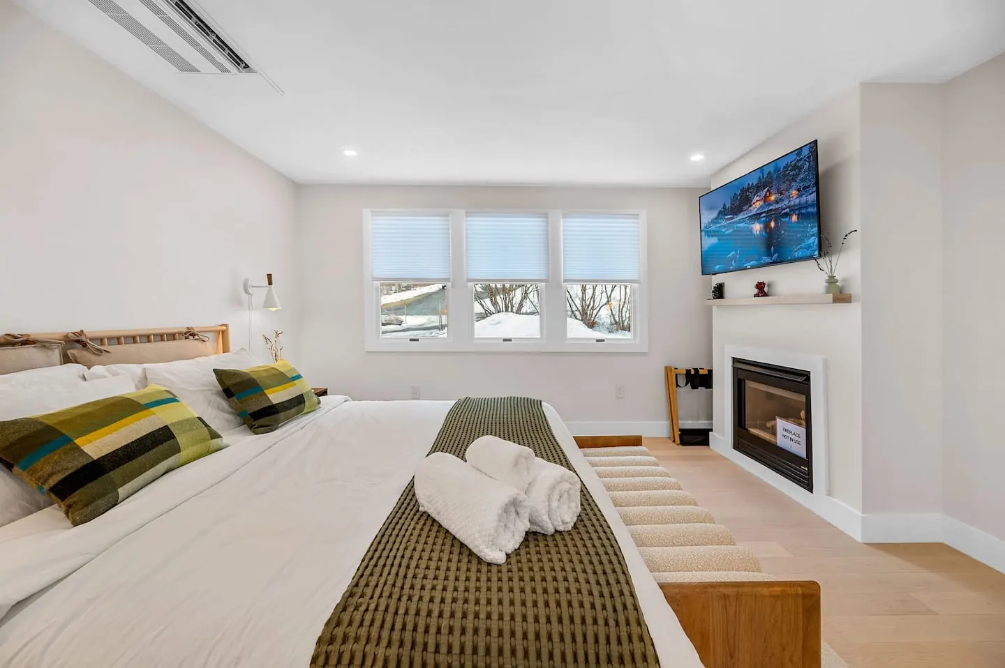 Primary suite from the other side, with warm layers and a wall fireplace