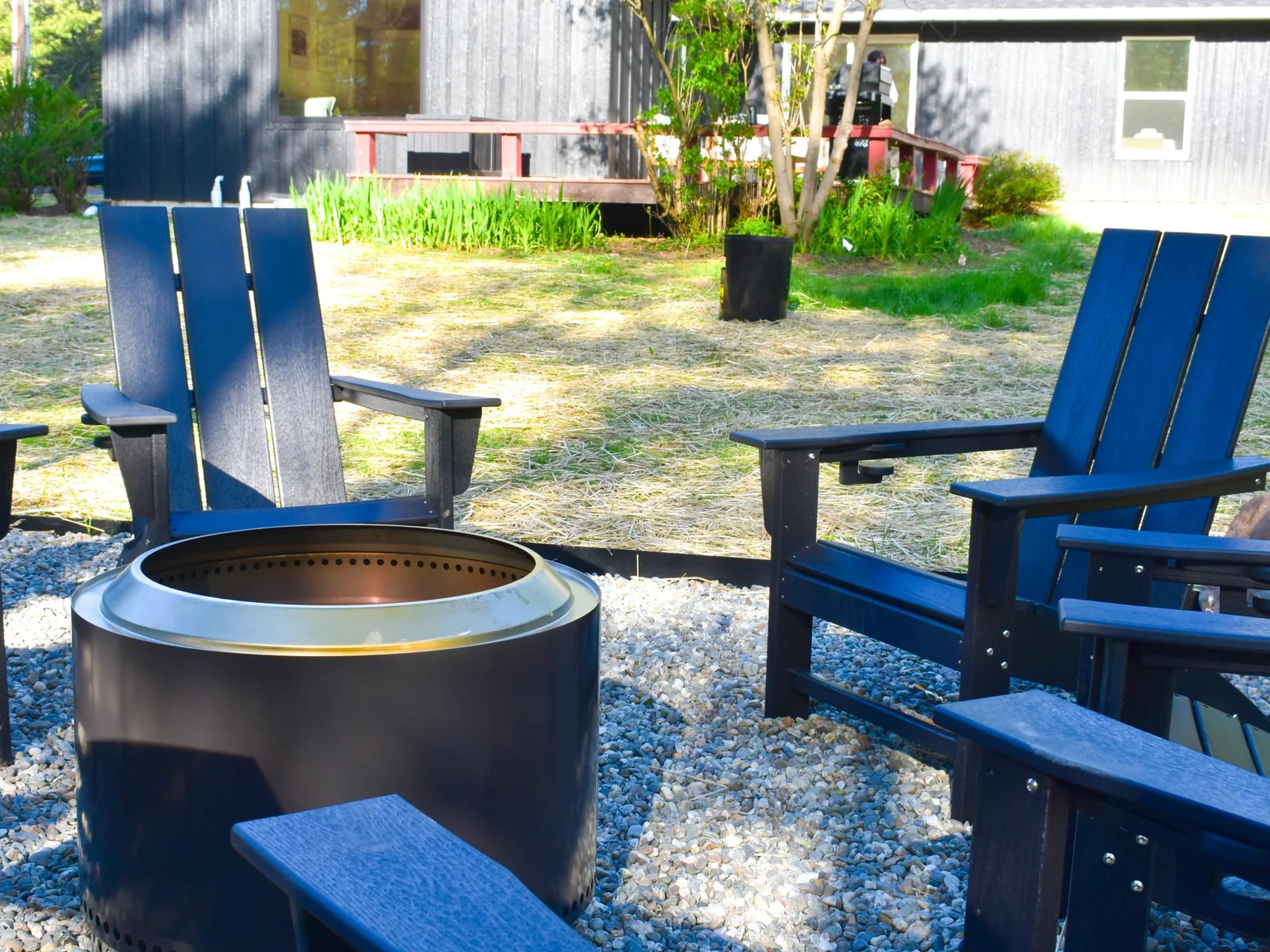 Solo Stove fire pit with Adirondack chairs beside the house
