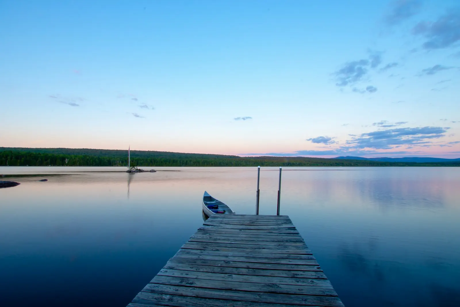 Dock on a calm Vermont lake at dusk