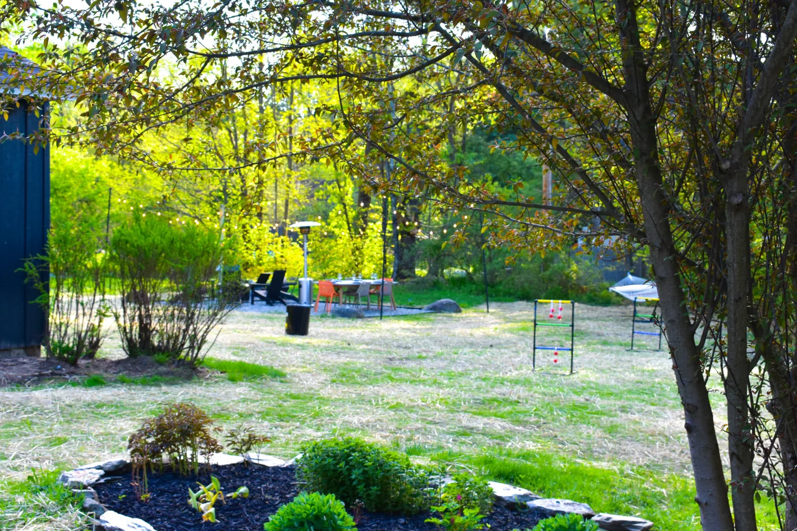Backyard view from the fire pit and dining area to the lawn games